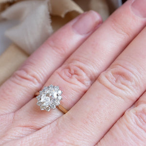 Oval diamond, diamond cluster ring shown on hand