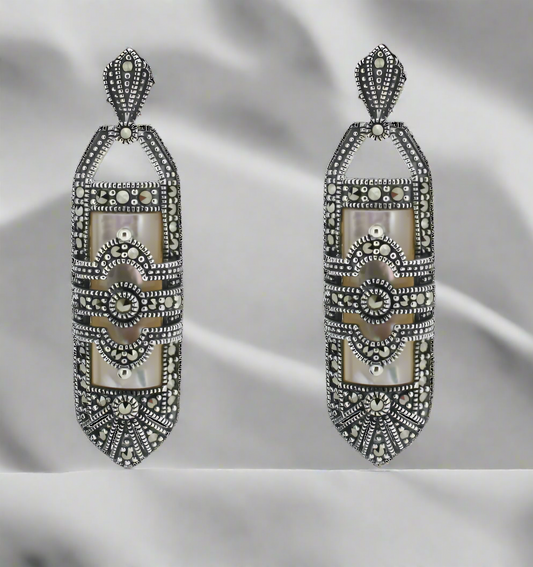 Decorative earrings with intricate designs on a white background