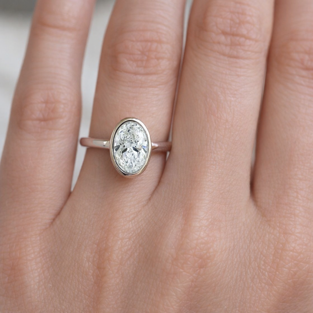 Diamond ring on a person's finger with a neutral background