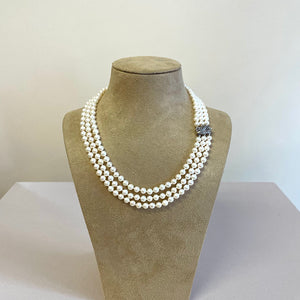 Three strand freshwater pearl necklace shown on stand