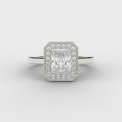 0.50ct Emerald Cut Diamond Engagement ring with a diamond halo surround and plain shoulders.  Centre Diamond Weight: 0.50ct  Centre Stone Cut: Emerald Cut  Diamond Weight on Halo: 0.15ct  Diamond Cut on Halo: Round Brilliant Cut  Total Diamond Weight: 0.65ct  Available in Yellow Gold, Rose Gold, White Gold and Platinum.  This ring is also available with Lab Grown Diamonds - contact us for further information.