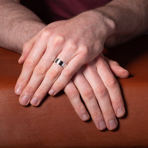 Men's white gold, flat court wedding ring shown on model
