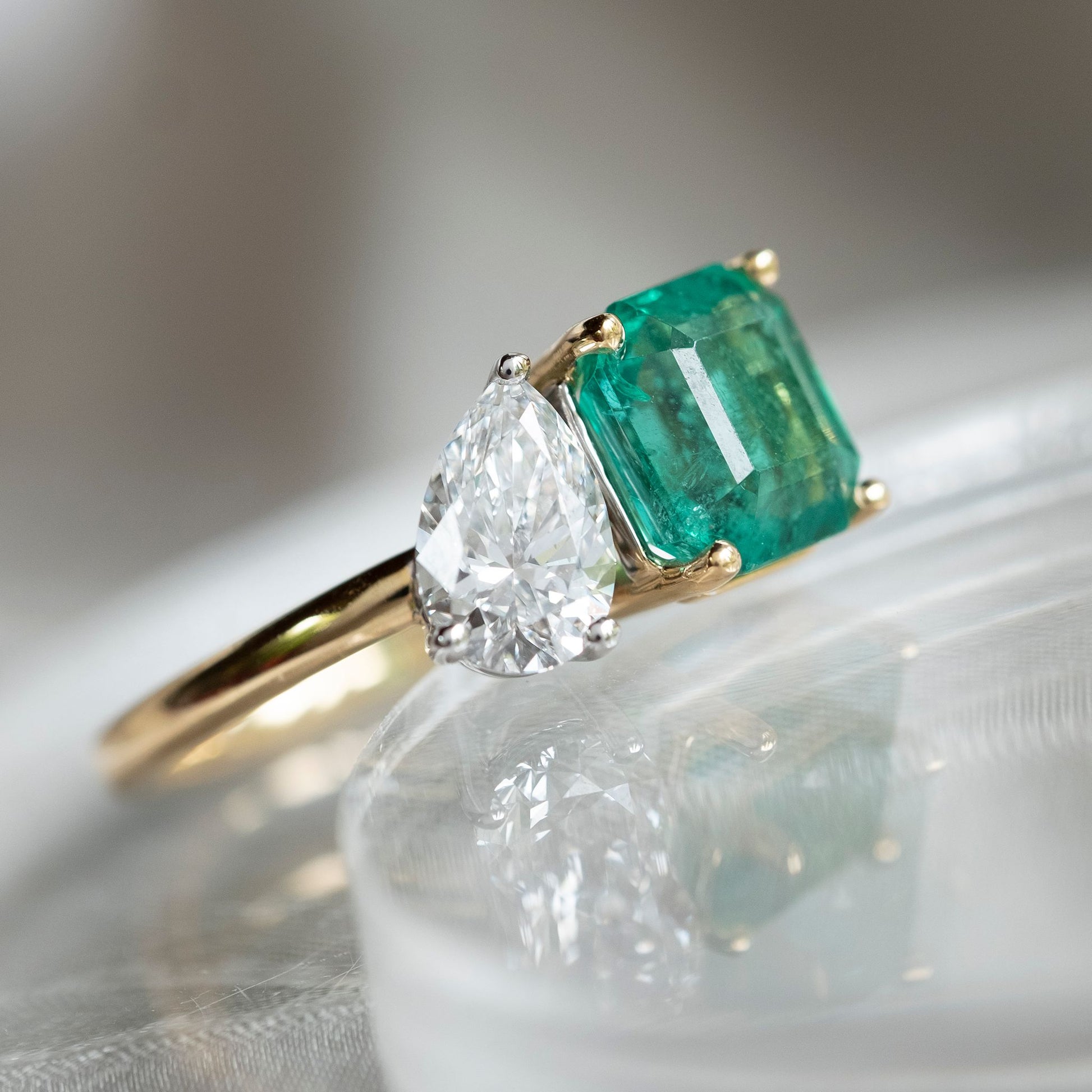 The toi et moi ring meaning “you and me” is one of the most historic ring setting styles that symbolizes love stories and partnerships.  This stunning ring has a Pear Cut Lab Grown Diamond - 0,8ct  Colour D  Clarity VS2  Sitting beside it is a 2.22ct Emerald   We have size N in stock