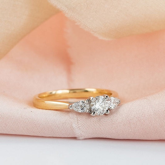 three stone diamond engagement ring, a solitaire centre stone with pear shaped diamond either side