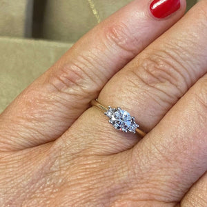 3 stone diamond engagement shown on hand