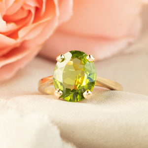 Peridot in a four claw 9ct gold ring setting