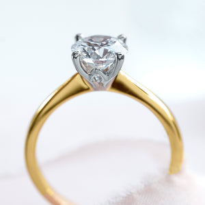 side profile of A yellow gold solitaire diamond ring with white gold claws