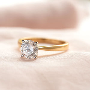 A yellow gold solitaire diamond ring with white gold claws